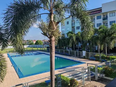 a swimming pool with a palm tree in front of a building at Las Enchanted kingdom Cozy Woody in Santa Rosa