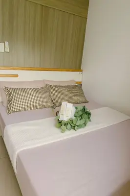 a bed with a book and a plant on it at Staycation near MOA Pasay at Shore Residences - Elizcape in Manila