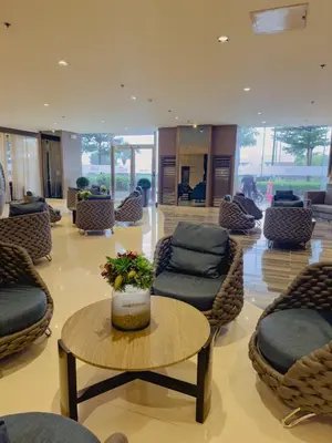 a lobby with couches and a table and chairs at Staycation near MOA Pasay at Shore Residences - Elizcape in Manila