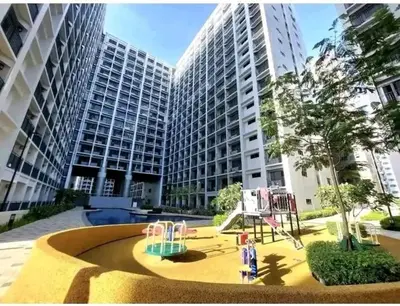 a playground in front of a large building at Entire 1 BR condo unit with balcony at MOA complex in Manila