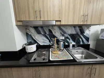 a kitchen counter with a sink and a stove at Entire 1 BR condo unit with balcony at MOA complex in Manila