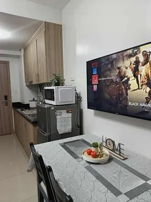 a kitchen with a table with a plate of food on it at Entire 1 BR condo unit with balcony at MOA complex in Manila