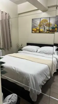 a bedroom with two beds and a painting on the wall at T3 Airport Condo Escape by JM and Ian in Manila