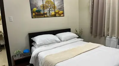 a bed in a bedroom with a picture on the wall at T3 Airport Condo Escape by JM and Ian in Manila