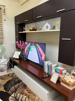 a desk with a monitor and books on it at T3 Airport Condo Escape by JM and Ian in Manila