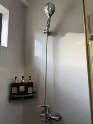 a shower head in a bathroom with a sink at T3 Airport Condo Escape by JM and Ian in Manila