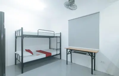 a room with two bunk beds and a desk at RedDoorz at Qhouzz near PUP in Manila