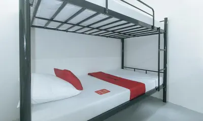 a bedroom with two bunk beds with red pillows at RedDoorz at Qhouzz near PUP in Manila