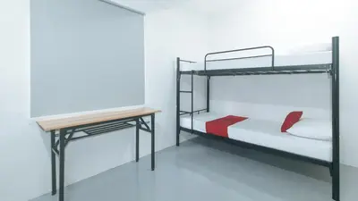 a room with two bunk beds and a desk at RedDoorz at Qhouzz near PUP in Manila