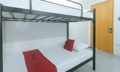 a bunk bed with a red pillow in a room at RedDoorz at Qhouzz near PUP in Manila