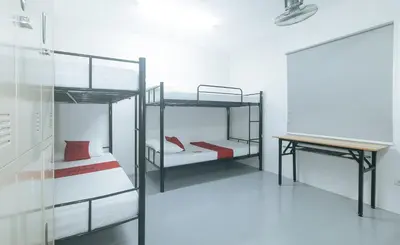 a room with two bunk beds and a desk at RedDoorz at Qhouzz near PUP in Manila