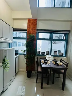 a kitchen with a table and chairs and a window at Newly Renovated 2-storey Loft at Greenbelt 1 Near Legaspi Park in Manila