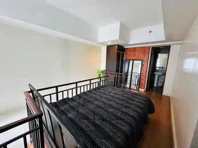 a bedroom with a bed on a balcony at Newly Renovated 2-storey Loft at Greenbelt 1 Near Legaspi Park in Manila