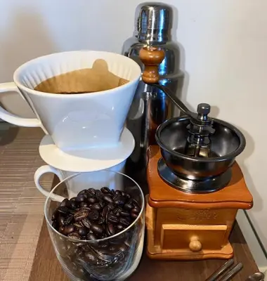 a cup of coffee and a bowl of coffee beans at 2 Bedroom with Massage Chair 15 minutes from NAIA in Manila