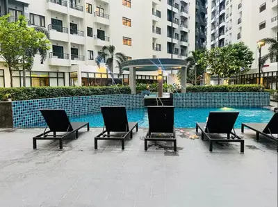 a group of chairs sitting in front of a swimming pool at 2 Bedroom with Massage Chair 15 minutes from NAIA in Manila