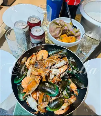 a plate of seafood and vegetables on a table at 2 Bedroom with Massage Chair 15 minutes from NAIA in Manila