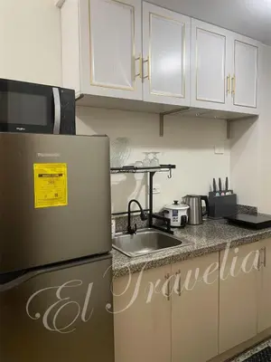 a kitchen with a refrigerator and a sink at 2 Bedroom with Massage Chair 15 minutes from NAIA in Manila