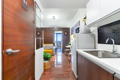 a kitchen with a sink and a refrigerator at 1BR Staycation at AIR Residences Makati City in Manila