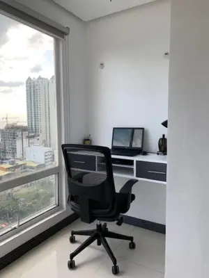 a desk with a computer in a room with a window at Birch Tower - 1BR with balcony in Manila