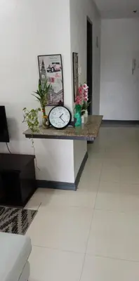 a table with a clock on it in a room at Birch Tower - 1BR with balcony in Manila