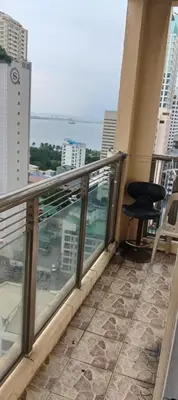 a balcony with a chair and a view of the ocean at Birch Tower - 1BR with balcony in Manila