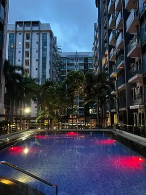 a large swimming pool in a city with tall buildings at Staycation By JEM - Across NAIA T3 in Newport City in Manila
