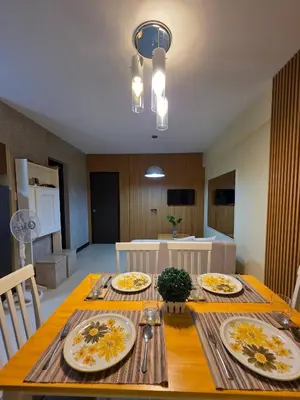 a dining room table with plates of food on it at The Yanoa Stay 2 Bedroom Condo in Manila