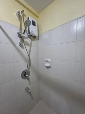 a bathroom with a shower with a toilet and a shower at The Yanoa Stay 2 Bedroom Condo in Manila
