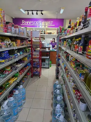 a supermarket aisle with a woman in the background at The Yanoa Stay 2 Bedroom Condo in Manila