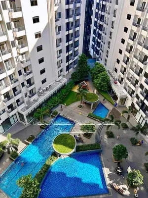 an overhead view of two pools in a courtyard with tall buildings at Sky Suites at Spring Residences Condotel near NAIA and SM Bicutan Mall in Manila