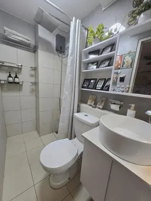 a white bathroom with a toilet and a sink at Zen Vibes Modern 2BR Asian Fusion Stay in Manila