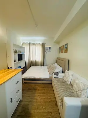 a small bedroom with a bed and a couch at Berkeley Breeze Staycation in Silang