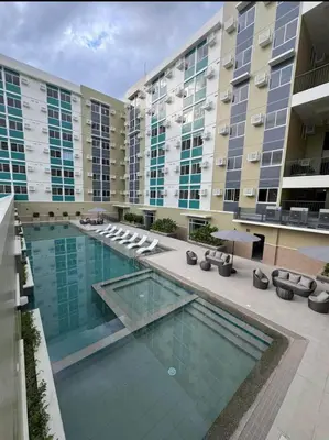 a swimming pool in front of a large building at Berkeley Breeze Staycation in Silang