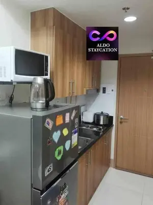 a kitchen with a stainless steel refrigerator and a microwave at Mall of Asia gateways shore 3 condotel in Manila