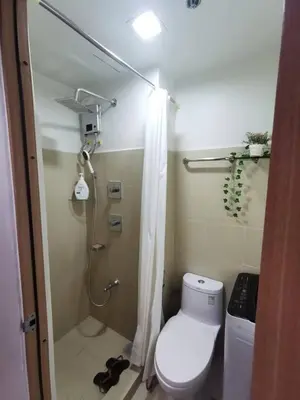 a bathroom with a toilet and a shower with a shower curtain at Mall of Asia gateways shore 3 condotel in Manila