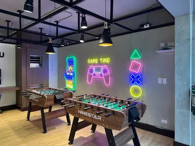 two foosball tables in a room with neon signs at Airport Home Base Trips Getaways 3pax balcony 6g in Manila