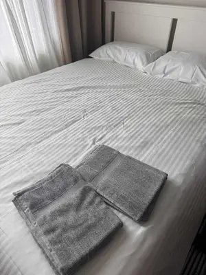 two towels sitting on top of a bed at Fully-furnished 1-br unit in Manila
