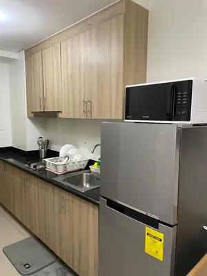 a kitchen with a refrigerator and a microwave at The Ren Suite Facing Amenities in Manila