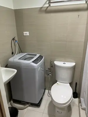 a small bathroom with a toilet and a sink at The Ren Suite Facing Amenities in Manila