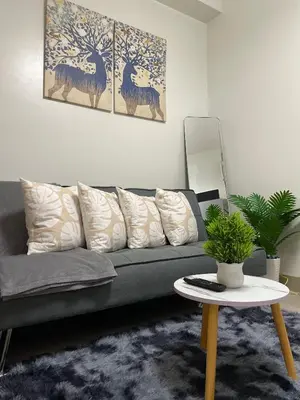 a living room with a gray couch and a table at The Ren Suite Facing Amenities in Manila