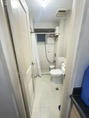 a small bathroom with a toilet and a shower at LaVerti 1BR Affordable staycation groups family in Manila