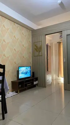 a living room with a flat screen tv on a wall at Scarlet Stay in Manila