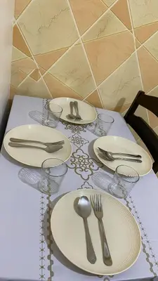 a table with plates and silverware on a table at Scarlet Stay in Manila