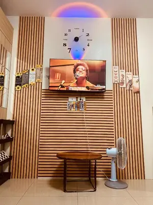 a wall with a clock and a table in a room at Scarlet Stay in Manila