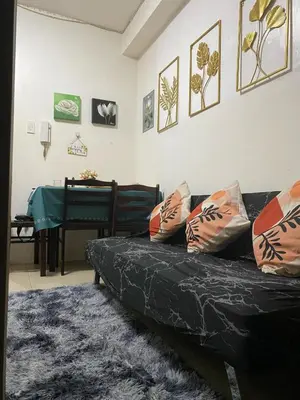 a living room with a black couch and a piano at Scarlet Stay in Manila