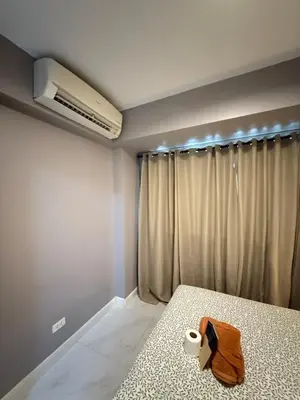 a bedroom with a bed with a towel on it at Bayhaus MNL - Pet-friendly Condo near MOA in Manila