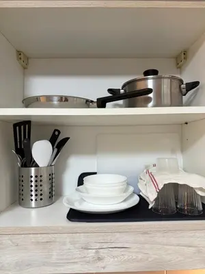 a kitchen shelf with plates and a pot on it at Bayhaus MNL - Pet-friendly Condo near MOA in Manila