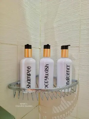 three shampoo bottles on a shelf in a bathroom at Natalie Staycation Buddies in Manila