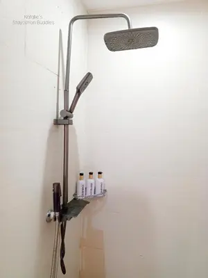 a shower with five bottles on a shelf in a bathroom at Natalie Staycation Buddies in Manila
