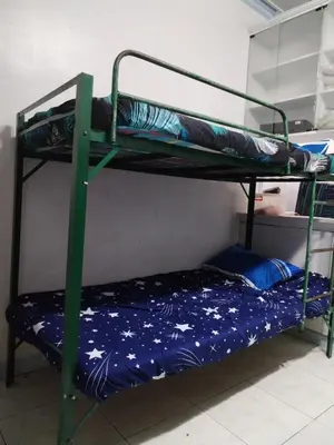 two bunk beds in a room with a blue bed at male bedspace in Manila